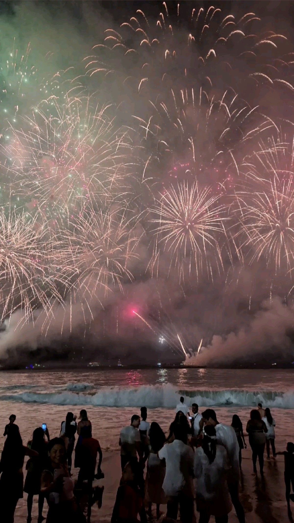 Silvesterfeuerwerk an der Copacabana, von der Menge am Strand aus gesehen